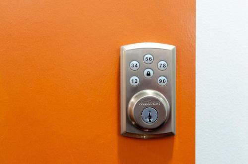 a close up of a remote control on an orange wall at Self Check-in-washer-dryer-4ksmart Tv-king Bed-gym in Tacoma