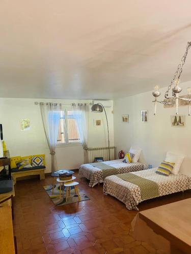 une chambre avec trois lits et une table dans l'établissement Grande maison de vacances jusqu'à 15 personnes, à quelques pas d'Aix-en-Provence, à Aix-en-Provence