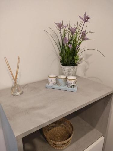 a table with three candles and flowers on it at Palmeral Suite in Grado