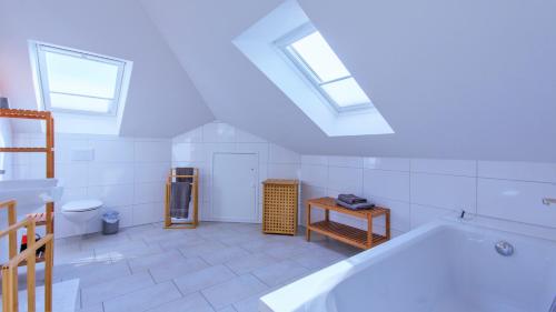 un bagno bianco con vasca e WC di Haus Amber Glowe a Glowe