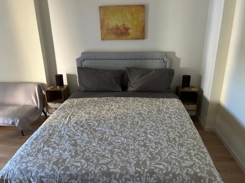 a bedroom with a bed with a gray comforter at Boa Vista Apartamento in Odivelas