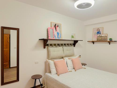 a bedroom with a bed with pink pillows and a mirror at Gio' Garden in Gabicce Mare