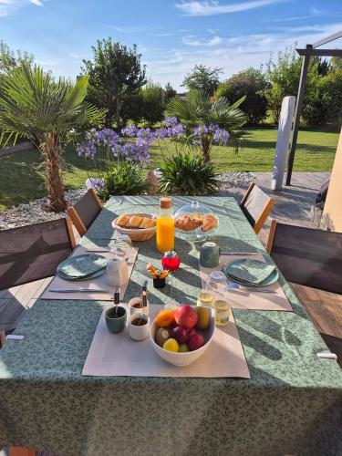 - une table avec une assiette de nourriture et un bol de fruits dans l'établissement Les Charmilles, à Escoville