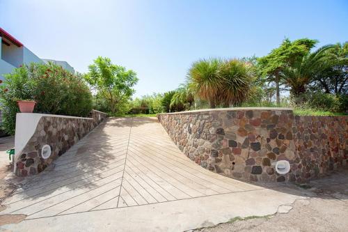 a stone retaining wall with a ramp in a yard at Villa Mulino Al Vento in Lipari