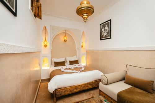 a bedroom with a bed and a couch at Riad Anya & SPA in Marrakech