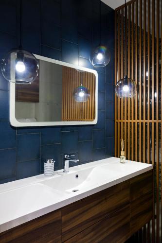 a bathroom with a white sink and a mirror at Old City apart in Lviv