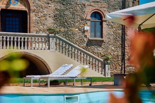 a pair of white chairs sitting next to a building at Tenuta Il Poggio - Luxury B&B in Felegara