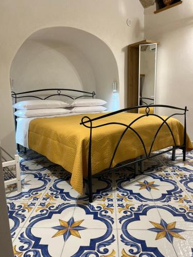 a bedroom with a bed with a yellow bedspread at Salvo's House in Furore