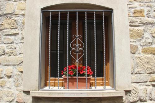 a window with a cage with flowers in a window sill at Casa Vacanze Sud e Magia in Castelmezzano