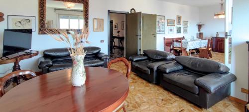 a living room with a table and leather furniture at RIVIERA, Large Four-Room Apartment with Balcony and Partial Lake View in Pallanza