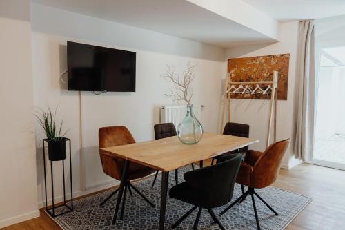 パッサウにあるCityHeart Appartement - Stadt Mitte - Stilvollのダイニングルームテーブル(椅子、花瓶付)