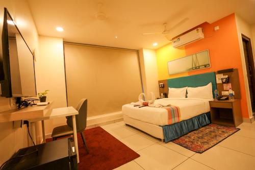 a hotel room with a bed and a desk at Hotel White Fields Hitec City, Hyderabad in Hyderabad