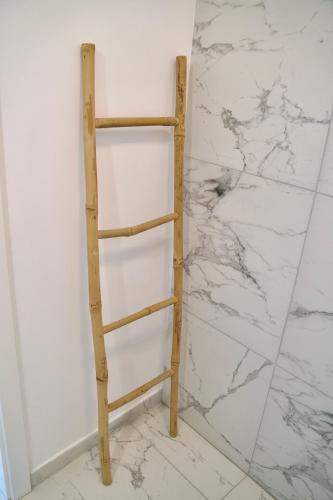 a wooden shelf against a wall with white marble at Tzatziki Studios in Kavala