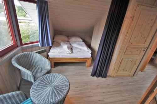 ein kleines Zimmer mit einem Bett und einem Stuhl in der Unterkunft Wildgans 271 in Mirow