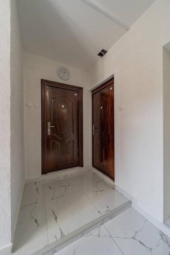 an empty room with two wooden doors in it at Lisa Zemun Spa Apartment in Zemun