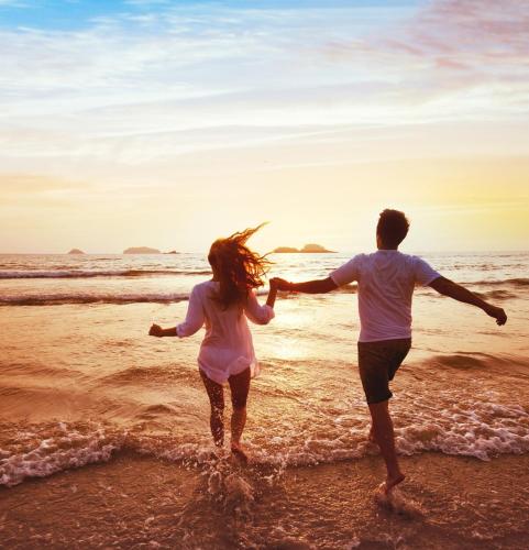 a man and a woman running on the beach at Jhadano 3br Pool & Gym Shuttle Gated in Florence Hall