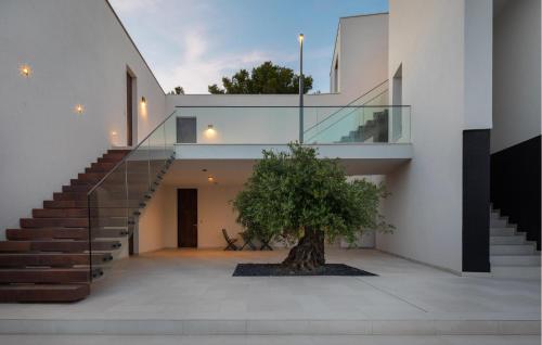 a tree in the courtyard of a house with a staircase at 1 Bedroom Nice Apartment In Betina in Betina