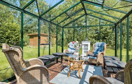 ToftlundにあるStunning Home In Toftlund With Wifiの椅子とテーブルのある緑の温室