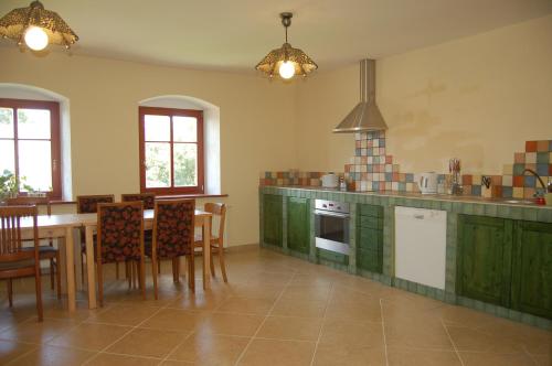 uma cozinha com armários verdes e uma mesa e cadeiras em Agroturystyka Dom pod Sową em Nawojów Łużycki