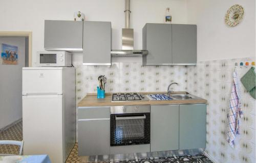 a kitchen with a stove and a refrigerator at Nice Home In Versilia in Vallecchia