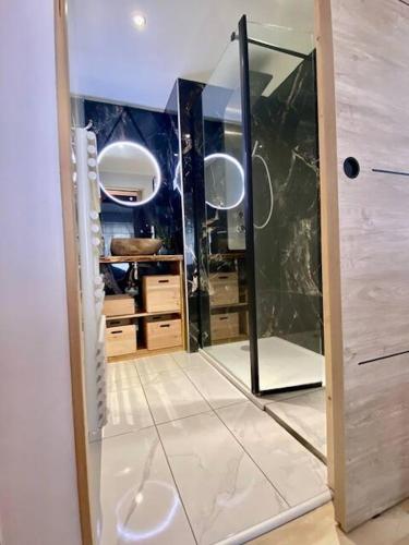 La salle de bains est pourvue d'une douche à l'italienne et d'un miroir. dans l'établissement T2 lumineux l' Edelweiss pied du Prorel avec garage privé, à Briançon