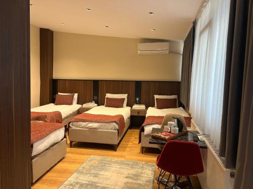 a hotel room with three beds and a table at Beşiktaş Konuk Evi Hotel in Istanbul