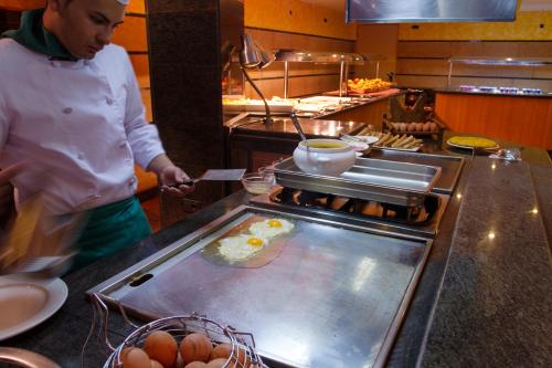 a chef standing in a kitchen preparing food at Tuc Blanc in Baqueira-Beret