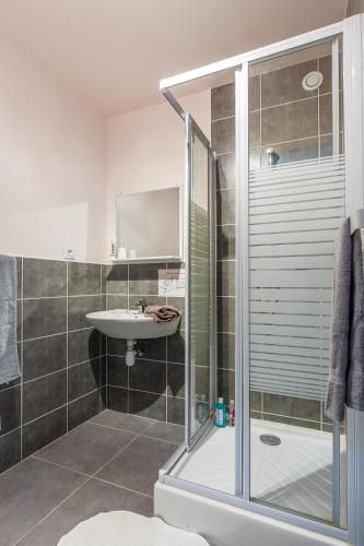 une salle de bain avec douche et lavabo dans l'établissement Auberge de jeunesse HI Valmeinier, à Valmeinier