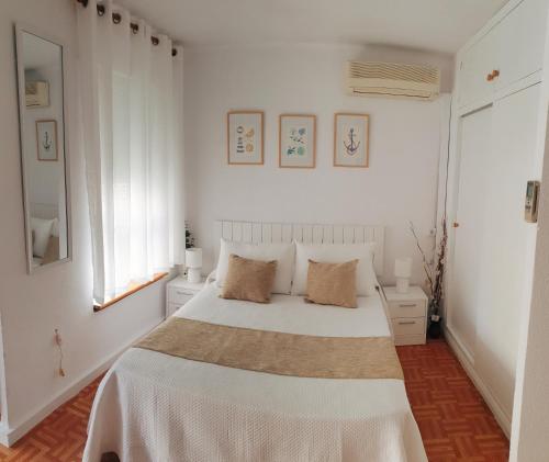 ein weißes Schlafzimmer mit einem großen Bett mit zwei Kissen in der Unterkunft Acogedor estudio Algarrobo-Costa in Algarrobo-Costa