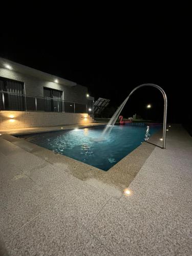 a swimming pool with a fountain at night at Casa dos Migueis in Cabeceiras de Basto