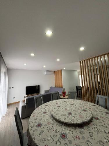 a room with a table and chairs and a television at Casa dos Migueis in Cabeceiras de Basto