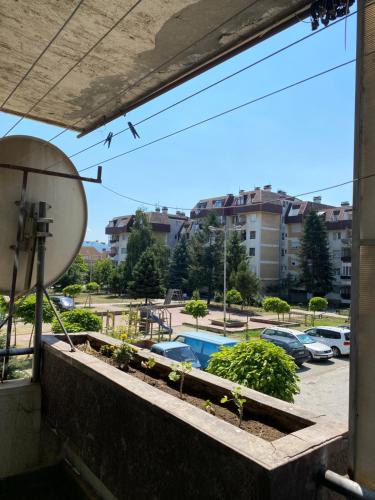 a balcony with a view of a parking lot at Sunlit City Apartment Gjakova in Gjakove