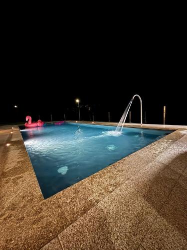 a swimming pool at night with a water fountain at Casa dos Migueis in Cabeceiras de Basto