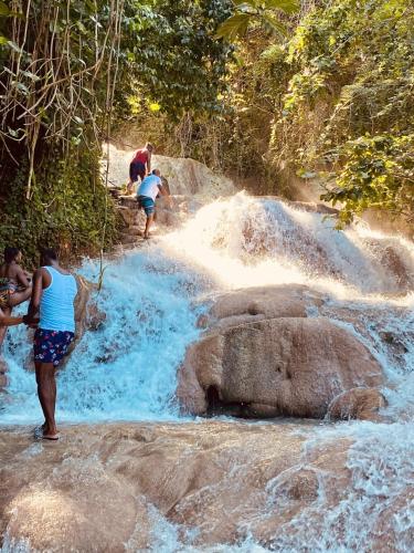 a group of people standing on rocks in a river at Jhadano 3br Pool & Gym Shuttle Gated in Florence Hall