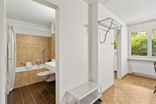 a bathroom with a sink and a toilet and a tub at Beautiful Boutique Apartment DRAHTZUG8 in Zürich