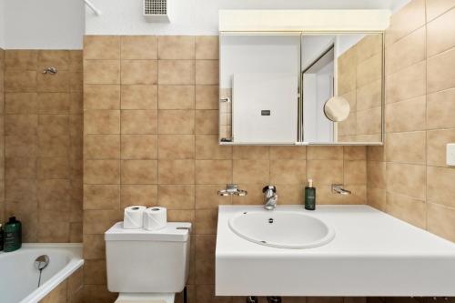 a bathroom with a sink and a toilet and a mirror at Beautiful Boutique Apartment DRAHTZUG8 in Zürich