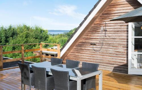 a patio with a table and chairs on a deck at 3 Bedroom Nice Home In Børkop in Børkop