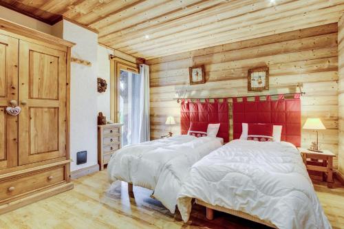 - 2 lits dans une chambre dotée de murs en bois dans l'établissement Chalet Chez Nous, à Morzine