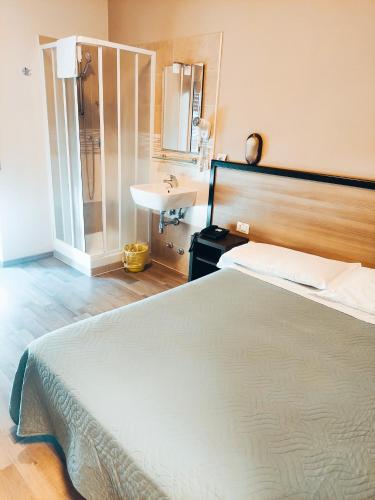 a bedroom with a large bed and a sink at Hotel Salus in Milan