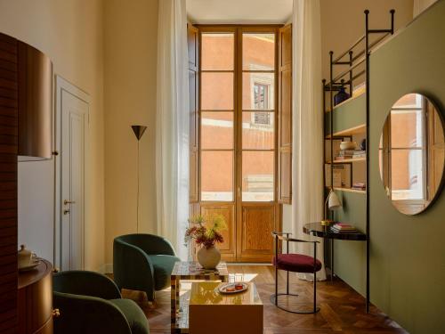 a living room with green chairs and a window at Palazzo Talìa - Small Luxury Hotels of the World in Rome