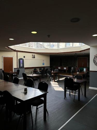 a dining room with tables and chairs and a large window at The Buck in Richmond