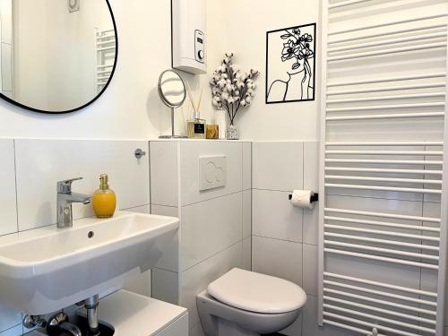 a white bathroom with a sink and a toilet at Apartment Ratingen - Balkon, Nähe DÜ-Messe und Airport in Ratingen