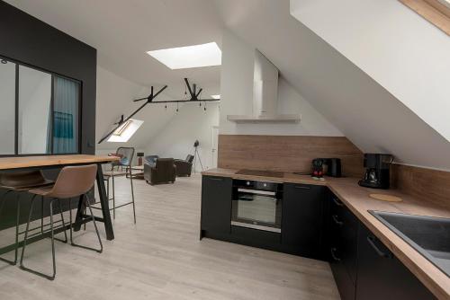 une cuisine avec des armoires noires et une table avec un comptoir dans l'établissement Le Winston Churchill, à Dinard