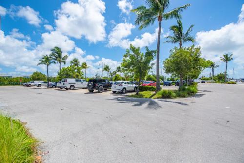 a parking lot with parked cars and palm trees at Awai's Floating Villa - Houseboat in Luxury Village in Key West