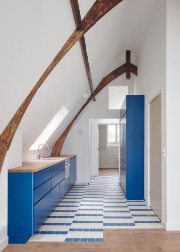 a kitchen with blue cabinets and a blue tile floor at Central Art Apartment - Nieuwmarkt area in Amsterdam