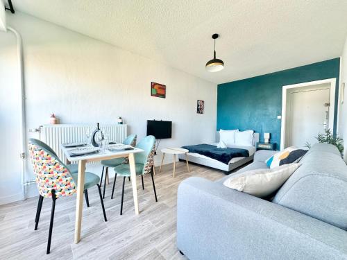 un salon avec un canapé, une table et un lit dans l'établissement Le Baudin avec vue sur Limoges, à Limoges