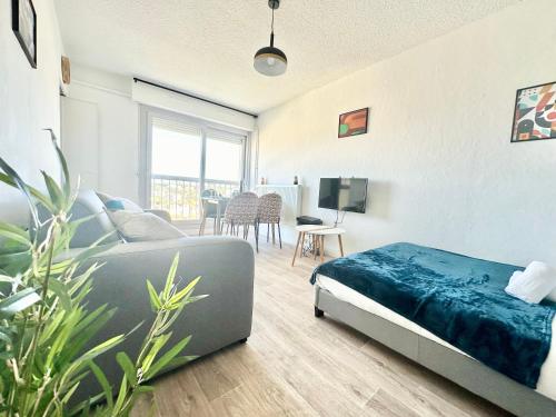 une chambre avec un lit et un canapé dans une pièce dans l'établissement Le Baudin avec vue sur Limoges, à Limoges