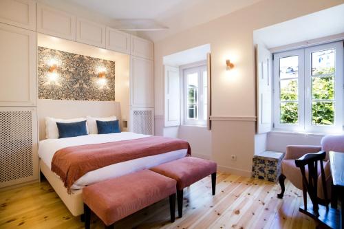 a bedroom with a bed and two windows at York House Lisboa Hotel in Lisbon