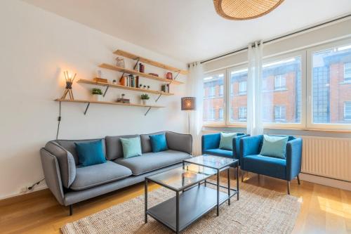 - un salon avec un canapé et deux fauteuils bleus dans l'établissement Appartement 3 chambres, centre-ville avec parking, à Tourcoing
