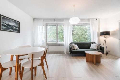 een woonkamer met een tafel en een bank bij Cosy flat with good transport connections and Free parking in Vantaa